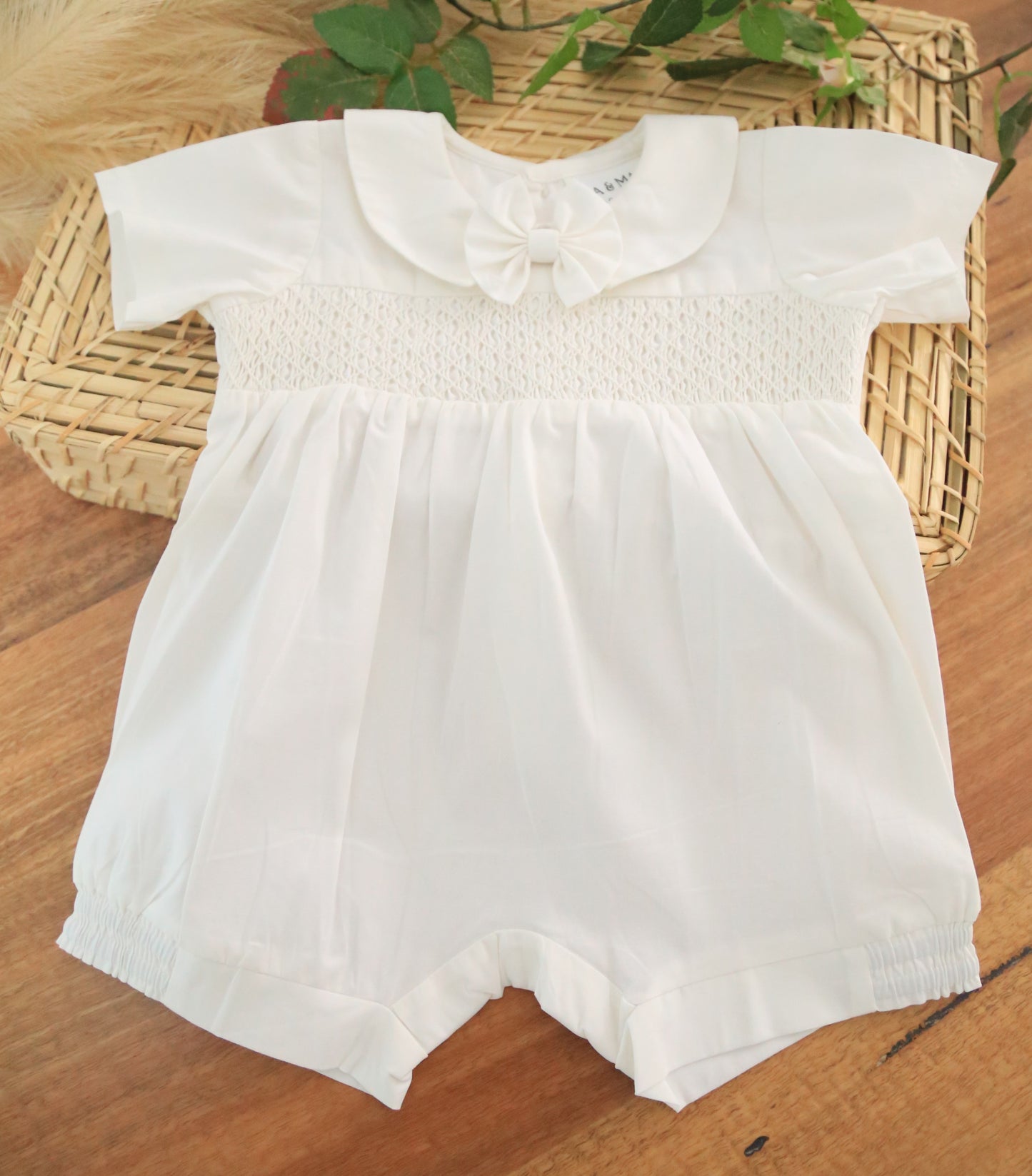 White baby romper with a collar and removable bow