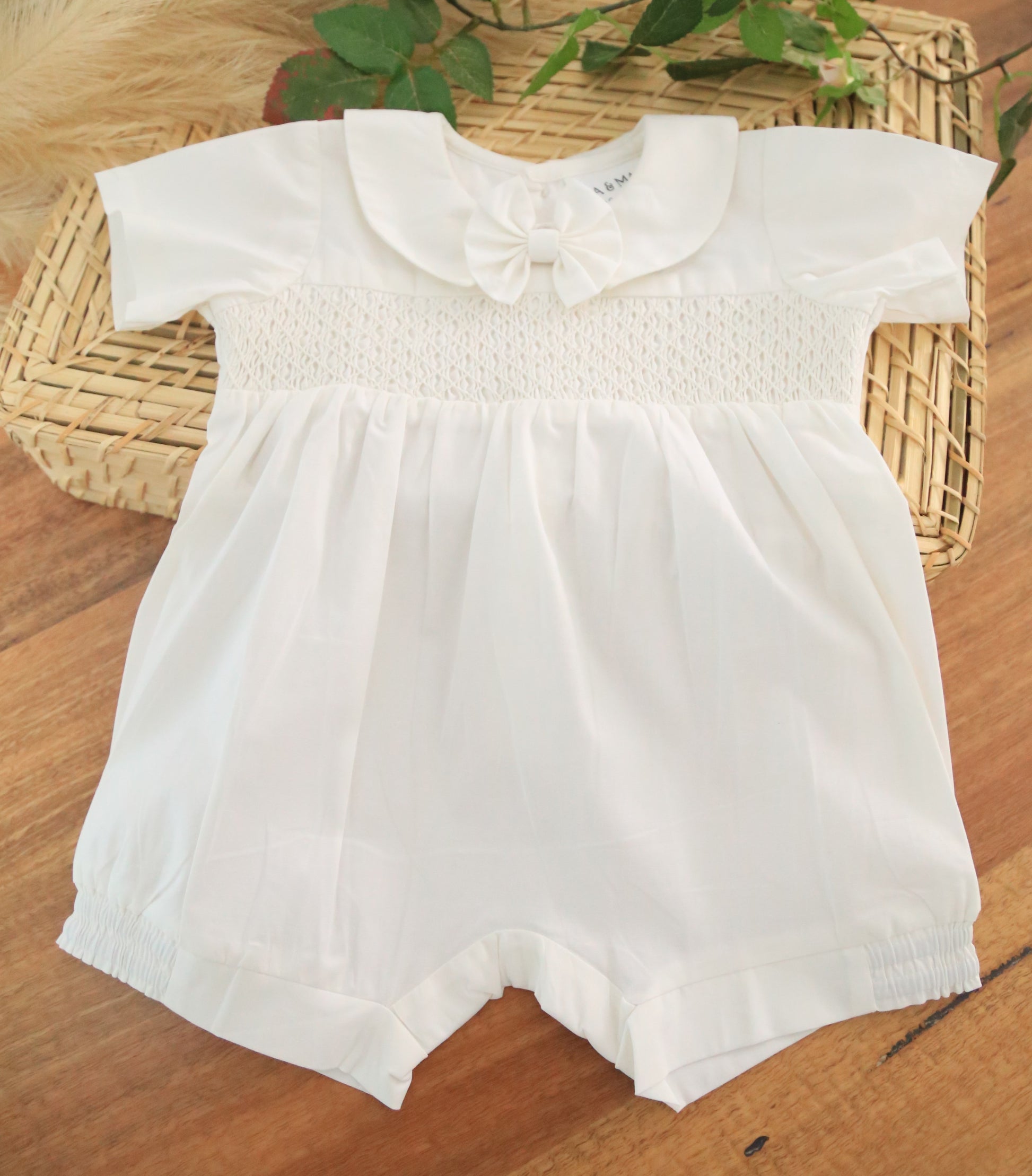 White baby romper with a collar and removable bow