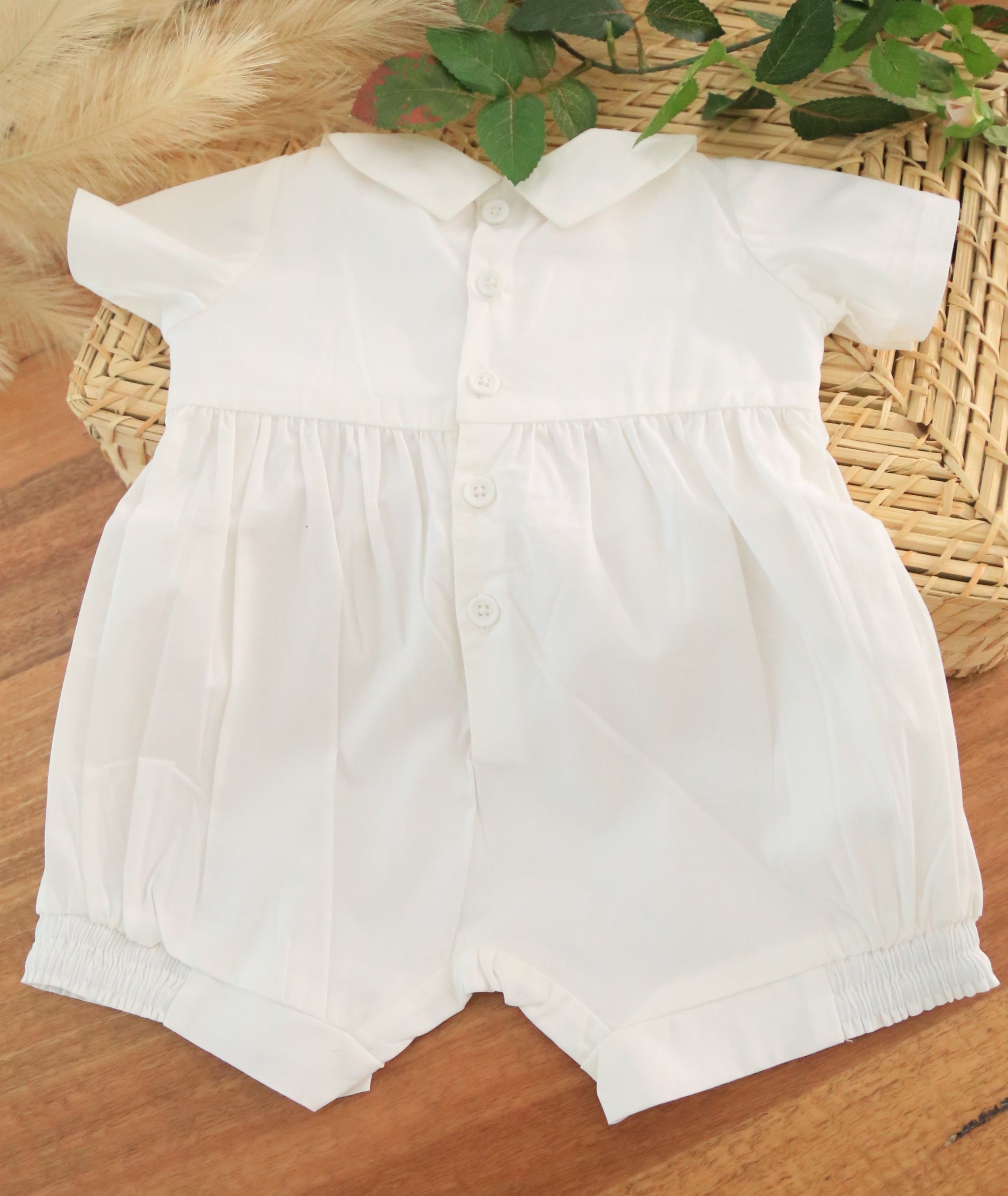 white baby boy romper with buttons at the back